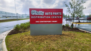 Photo of red & gray O'reilly monument sign in grassy area in Stafford, VA. Sign was manufactured & installed by Distinct Sign Solutions in Fredericksburg, VA