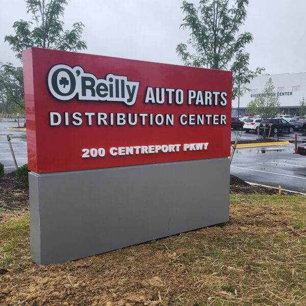 Red monument sign for O’Reilly Auto Parts Distribution Center displaying address and branding