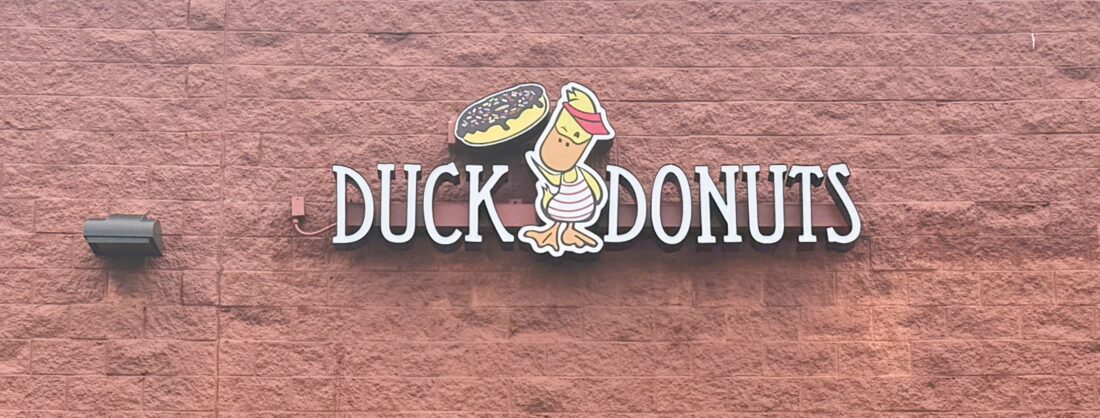 Photo of Duck Donuts channel letter sign mounted to block wall in Fredericksburg, VA. Sign was manufactured & installed by Distinct Sign Solutions in Fredericksburg, VA.