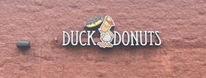 Photo of Duck Donuts channel letter sign mounted to block wall in Fredericksburg, VA. Sign was manufactured & installed by Distinct Sign Solutions in Fredericksburg, VA.