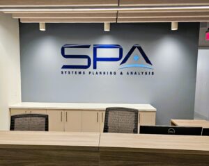 Photo of blue acrylic wall sign for SPA mounted to gray wall in Arlington, VA. Sign was manufactured & installed by Distinct Sign Solutions in Fredericksburg, VA
