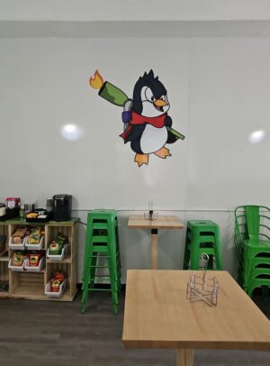 Photo of penguin mascot mounted as vinyl graphic on interior wall at restaurant in downtown Fredericksburg, VA. Graphic was manufactured & installed by Distinct Sign Solutions in Fredericksburg, VA