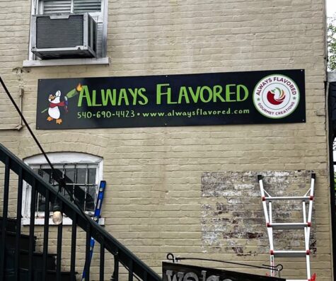 Photo of black background sign with various bright colors for Always Flavored mounted to brick wall at Always Flavored in Downtown Fredericksburg, VA. Sign was installed by Distinct Sign Solutions in Fredericksburg, VA