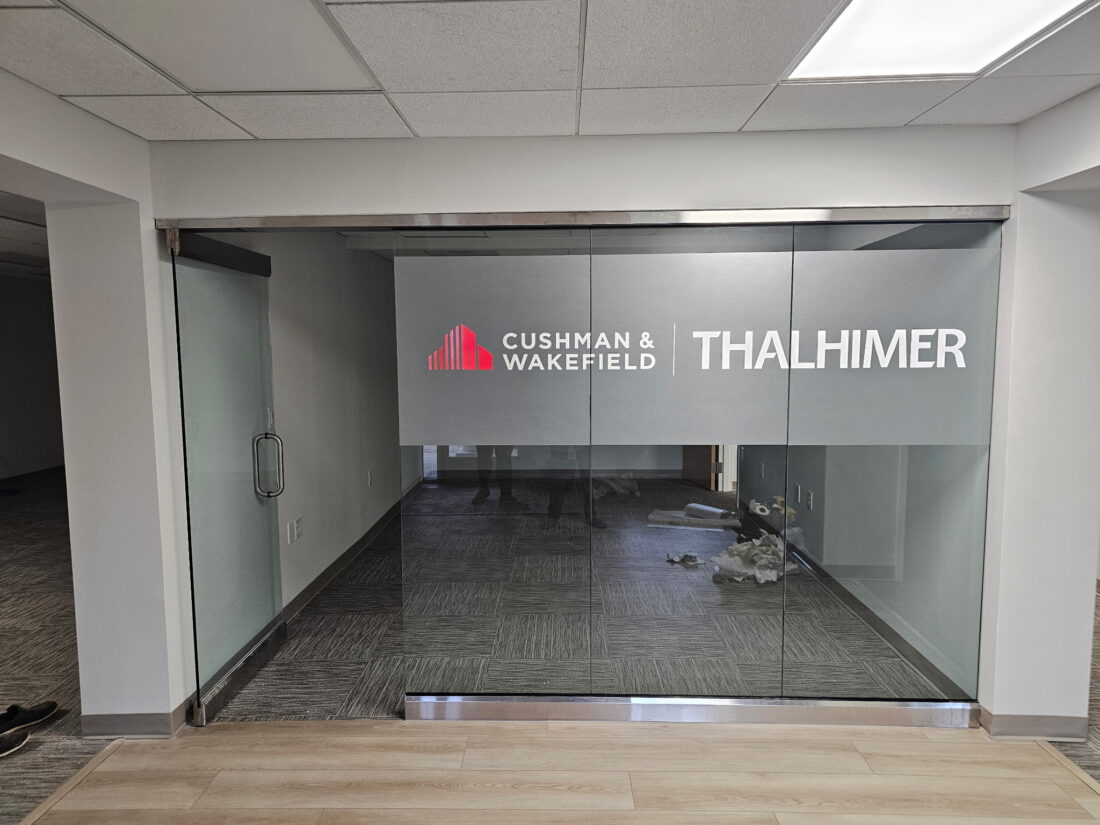 Photo of frosted, red, and white vinyl graphics to glass panes in conference room for Thalhimer in Fredericksburg, VA. Graphics were manufactured & installed by Distinct Sign Solutions in Fredericksburg, VA