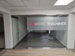 Photo of frosted, red, and white vinyl graphics to glass panes in conference room for Thalhimer in Fredericksburg, VA. Graphics were manufactured & installed by Distinct Sign Solutions in Fredericksburg, VA