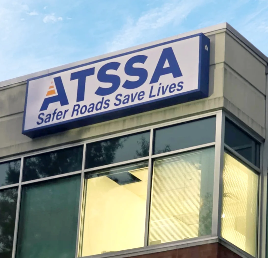 Photo of blue cabinet with white flex face insert showing off ATSSA logo. Sign is mounted to tall building in Stafford, VA. Sign was manufactured & installed by Distinct Sign Solutions in Fredericksburg, VA