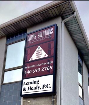 Photo of black sign cabinet with various white, black and burgundy sign panels affixed to EIFS wall in Stafford, VA business park. Sign was manufactured & installed by Distinct Sign Solutions in Fredericksburg, VA