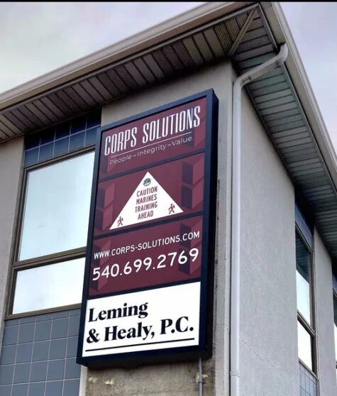 Photo of black sign cabinet with various white, black and burgundy sign panels affixed to EIFS wall in Stafford, VA business park. Sign was manufactured & installed by Distinct Sign Solutions in Fredericksburg, VA