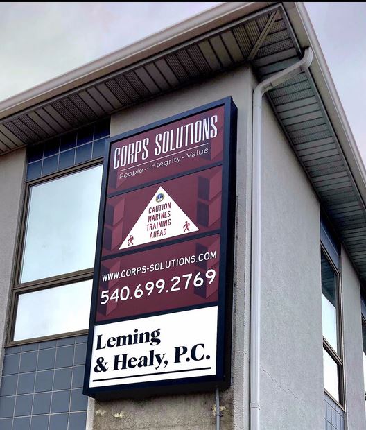 Photo of black sign cabinet with various white, black and burgundy sign panels affixed to EIFS wall in Stafford, VA business park. Sign was manufactured & installed by Distinct Sign Solutions in Fredericksburg, VA