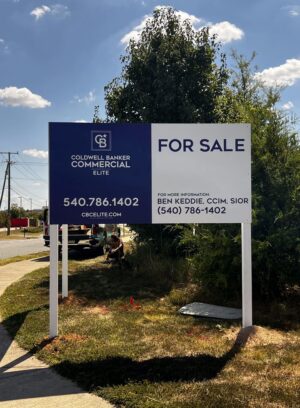 Photo of large post & panel sign affixed to white posts in grassy area. Sign is displaying FOR SALE for Coldwell Banker Elite, located in Stafford, VA. Sign was manufactured & installed by Distinct Sign Solutions in Fredericksburg VA