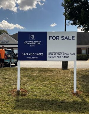 Photo of large post & panel sign affixed to white posts in grassy area. Sign is displaying FOR SALE for Coldwell Banker Elite, located in Spotsylvania, VA. Sign was manufactured & installed by Distinct Sign Solutions in Fredericksburg VA