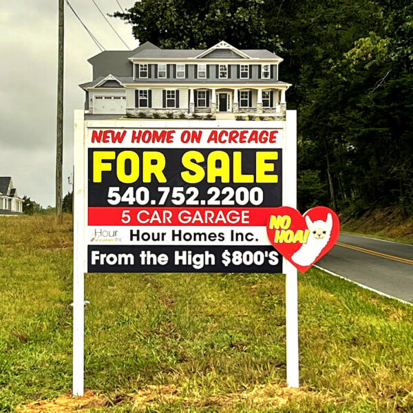 Hour Homes Inc. custom home builder signs showcasing a new home on acreage with a five-car garage.