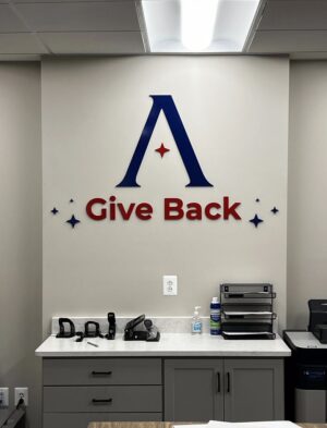 Photo of blue & red acrylic wall sign affixed to standard drywall in Atlantic Builders Headquarters. Sign was manufactured & installed by Distinct Sign Solutions in Fredericksburg, VA.