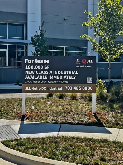 Photo of large post & panel sign affixed to white posts in grassy area. Sign is displaying FOR LEASE for JLL Mid Atlantic in Gaithersburg, MD. Sign was manufactured & installed by Distinct Sign Solutions in Fredericksburg VA