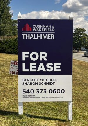 Photo of large post & panel sign affixed to white posts in grassy area. Sign is displaying FOR LEASE for Thahlimer, located in Stafford, VA. Sign was manufactured & installed by Distinct Sign Solutions in Fredericksburg VA