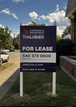 Photo of large post & panel sign affixed to white posts in grassy area. Sign is displaying FOR LEASE for Thahlimer Properties, located in Fredericksburg, VA. Sign was manufactured & installed by Distinct Sign Solutions in Fredericksburg VA