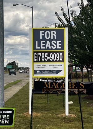 Photo of large post & panel sign affixed to white posts in grassy area. Sign is displaying FOR LEASE for Virginia Properties, located in Spotsylvania, VA. Sign was manufactured & installed by Distinct Sign Solutions in Fredericksburg VA