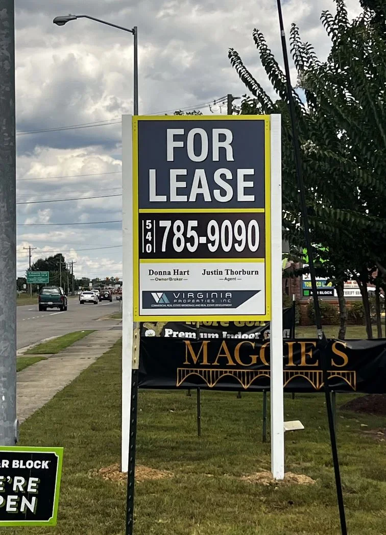 Photo of large post & panel sign affixed to white posts in grassy area. Sign is displaying FOR LEASE for Virginia Properties, located in Spotsylvania, VA. Sign was manufactured & installed by Distinct Sign Solutions in Fredericksburg VA