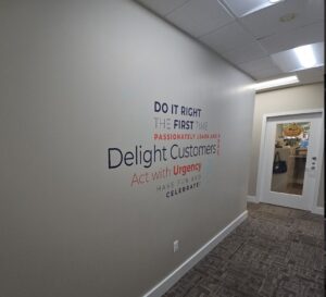 Photo of vinyl word cloud attached to wall in Atlantic Builder's headquarters. Graphic was manufactured & installed by Distinct Sign Solutions in Fredericksburg, VA