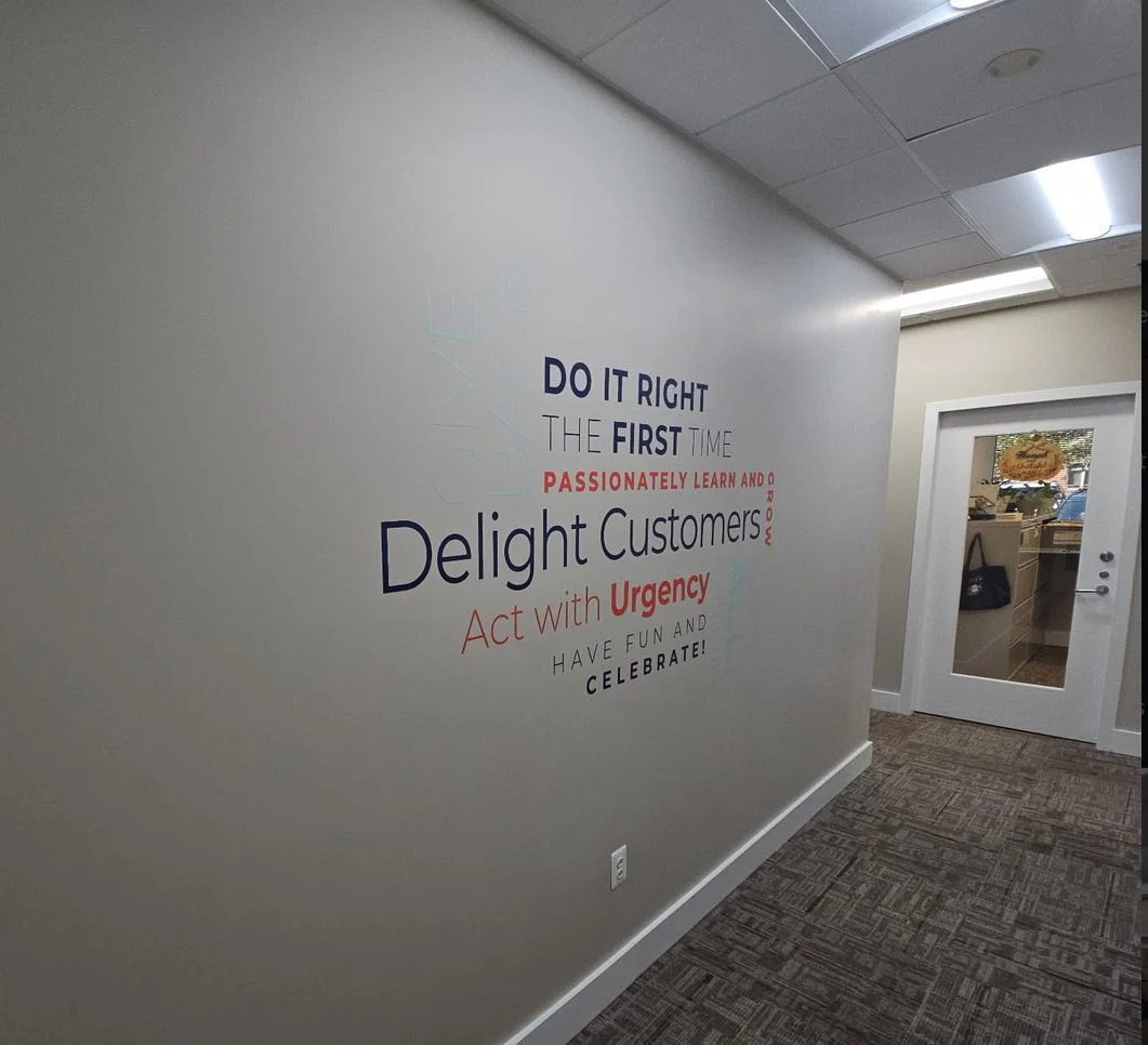 Photo of vinyl word cloud attached to wall in Atlantic Builder's headquarters. Graphic was manufactured & installed by Distinct Sign Solutions in Fredericksburg, VA