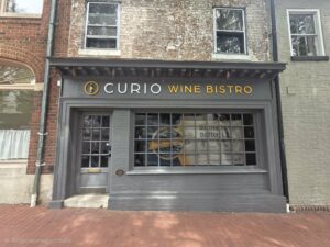 Acrylic business sign mounted on the exterior of a commercial building.